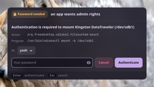 The password window: a Password needed pill in the top bar, polkit's message, the action and program, who to authenticate as, the password field with Cancel and Authenticate, and the keys in the footer